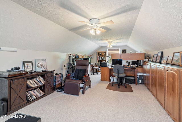 carpeted home office with vaulted ceiling, a textured ceiling, and ceiling fan