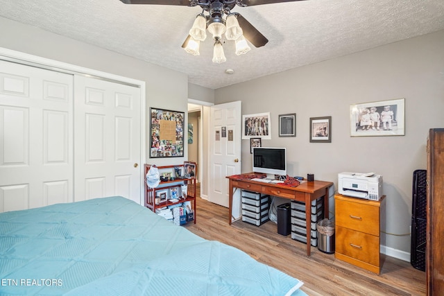 bedroom featuring a textured ceiling, ceiling fan, light hardwood / wood-style flooring, and a closet