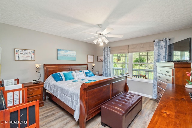 bedroom with ceiling fan, a textured ceiling, and light hardwood / wood-style floors