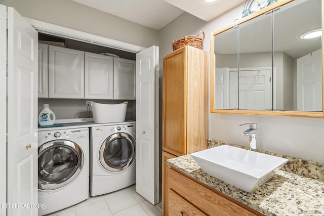 laundry room featuring light tile patterned floors, cabinets, sink, and independent washer and dryer