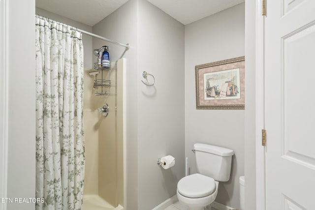 bathroom featuring toilet and a shower with shower curtain