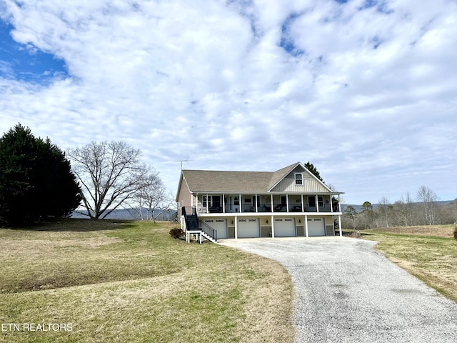 view of front of house with a garage, a front yard, and covered porch