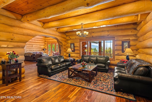 living room featuring a chandelier, hardwood / wood-style flooring, wooden ceiling, beam ceiling, and log walls