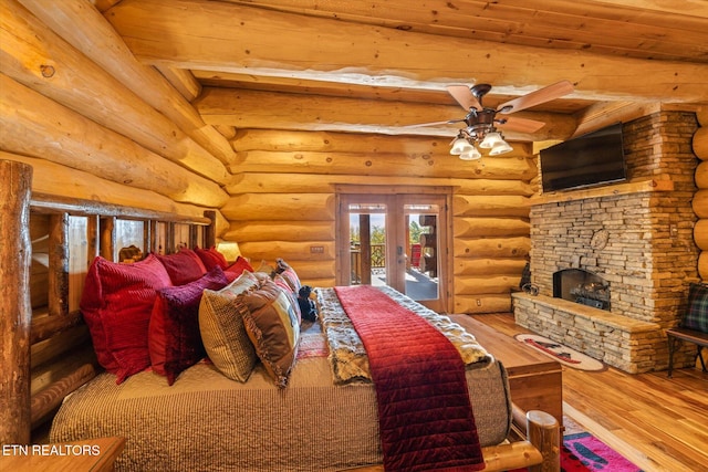 bedroom with a stone fireplace, access to outside, hardwood / wood-style flooring, and wooden ceiling