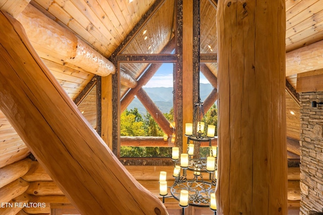 interior details featuring a mountain view, wood ceiling, log walls, and beam ceiling