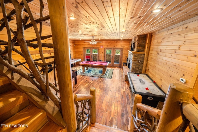 rec room with wood walls, french doors, hardwood / wood-style flooring, and wooden ceiling