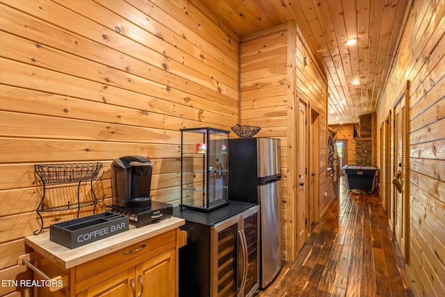 kitchen featuring wood walls, wine cooler, wood ceiling, dark wood-type flooring, and stainless steel fridge