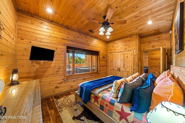 bedroom featuring wood walls, hardwood / wood-style flooring, ceiling fan, and wooden ceiling