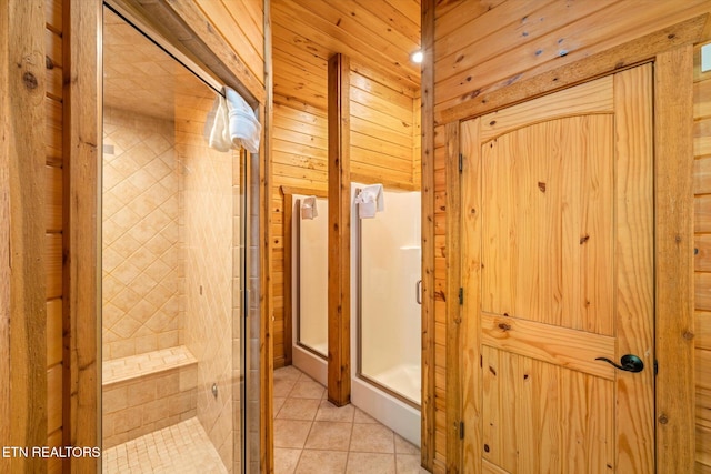 bathroom with tile patterned flooring, wooden walls, and a shower with shower door