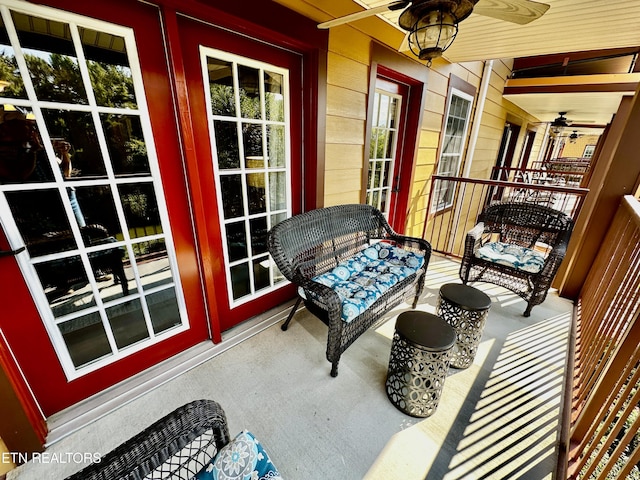 balcony featuring covered porch, ceiling fan, and french doors