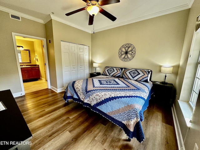 bedroom with baseboards, visible vents, wood finished floors, and crown molding