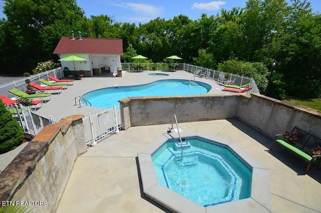 community pool with fence, a community hot tub, and a patio area