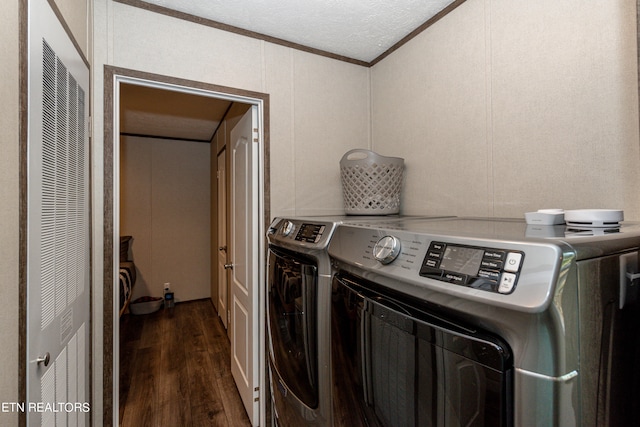 clothes washing area with washer and clothes dryer, ornamental molding, and dark wood-type flooring