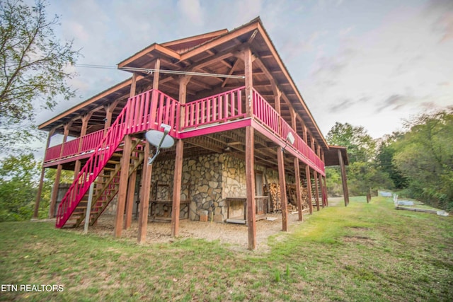 rear view of property featuring a lawn and a deck