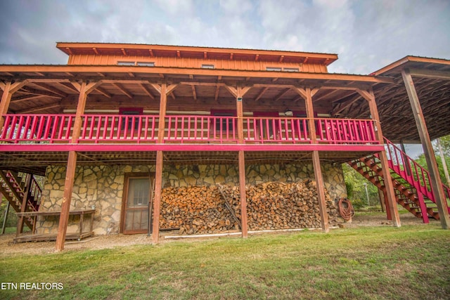 rear view of house with a deck and a lawn