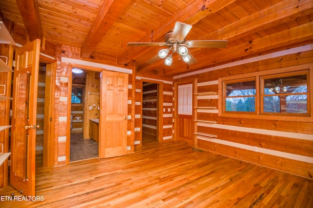 unfurnished room featuring ceiling fan, wooden ceiling, light wood-type flooring, and beamed ceiling