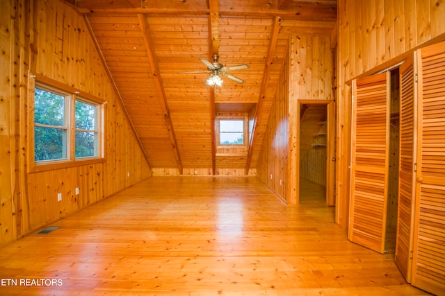 additional living space with wood walls, light hardwood / wood-style floors, wooden ceiling, and vaulted ceiling with beams