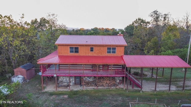 exterior space with a deck, a carport, and a storage unit