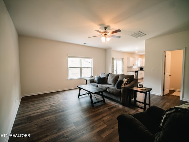 living room with ceiling fan and dark hardwood / wood-style flooring