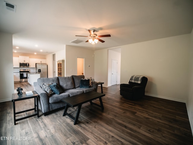 living room featuring ceiling fan and dark hardwood / wood-style flooring