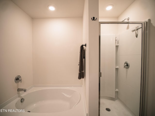 bathroom featuring shower with separate bathtub