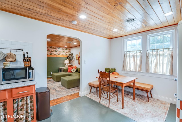 dining space with wood ceiling and concrete floors