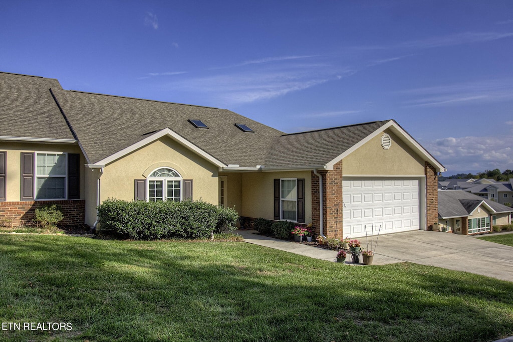 ranch-style home with a front lawn and a garage