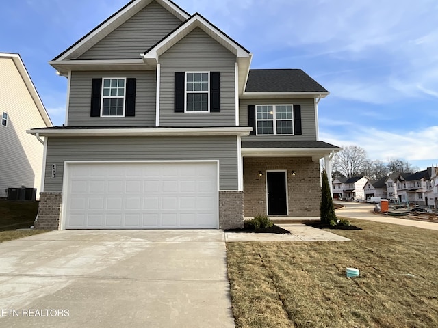 front of property featuring central AC, a garage, and a front yard