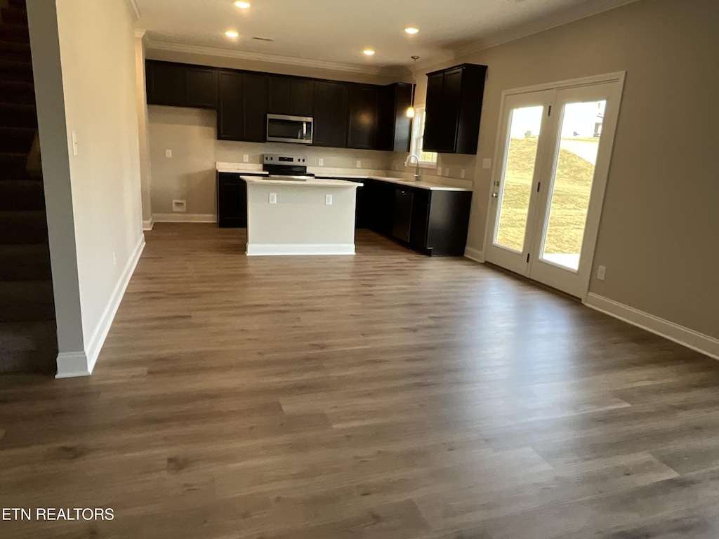 kitchen featuring hardwood / wood-style floors, sink, a center island, stainless steel appliances, and crown molding