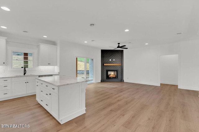 kitchen with white cabinetry, light hardwood / wood-style floors, and sink