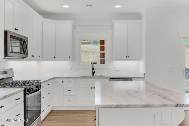 kitchen featuring white cabinetry, light hardwood / wood-style flooring, appliances with stainless steel finishes, and sink