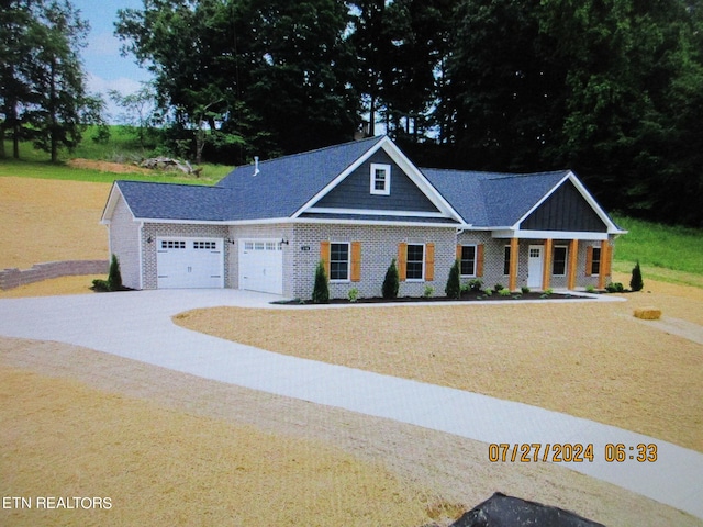 craftsman inspired home featuring a garage, driveway, and brick siding