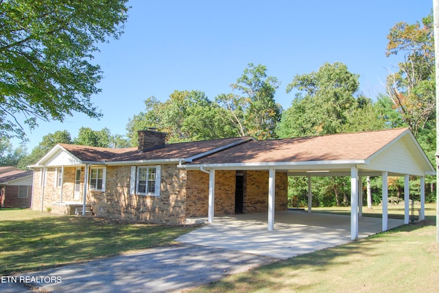 view of front of property featuring a front lawn and a carport