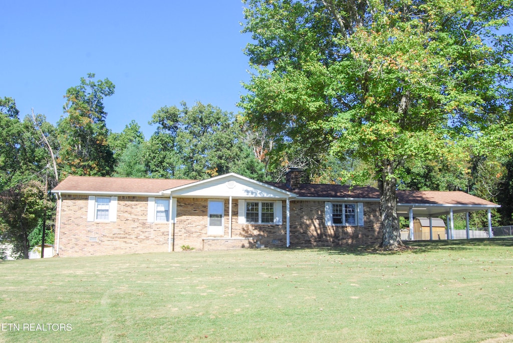 view of front of house featuring a carport and a front lawn