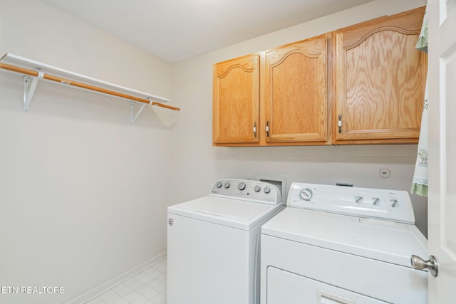 clothes washing area with cabinets and washing machine and dryer