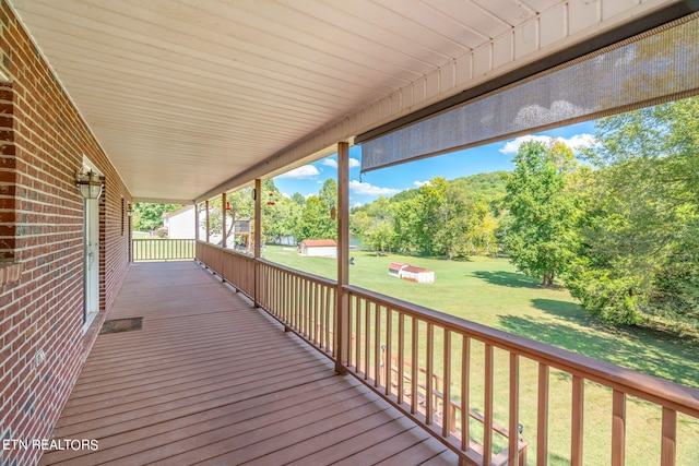 wooden deck featuring a lawn