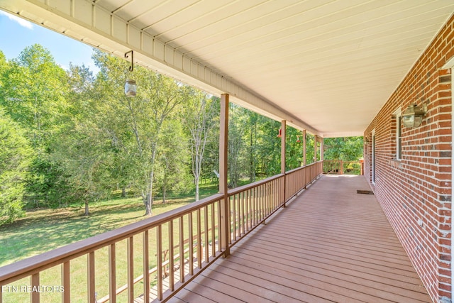 wooden terrace with a yard and covered porch