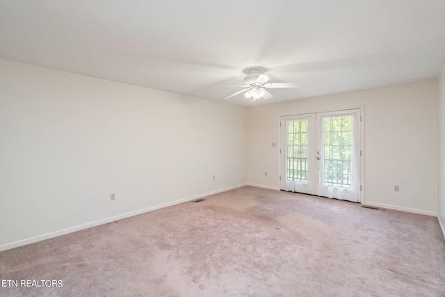 empty room featuring french doors, light colored carpet, and ceiling fan