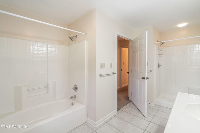 bathroom with tile patterned flooring, vanity, and tiled shower / bath