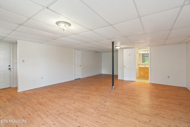 basement with a drop ceiling and light hardwood / wood-style floors