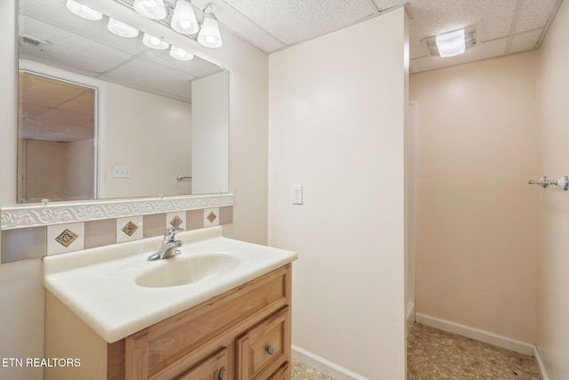 bathroom with vanity and a drop ceiling