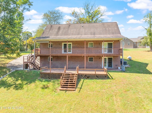 rear view of property featuring a wooden deck and a lawn