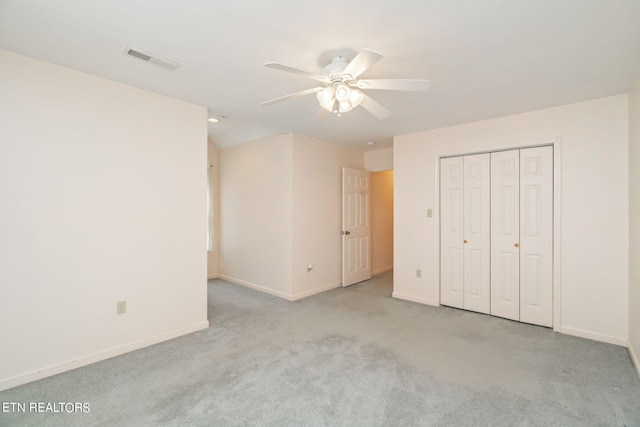 unfurnished bedroom with ceiling fan, a closet, and light colored carpet