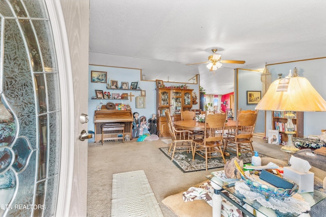 carpeted dining area featuring a textured ceiling and ceiling fan