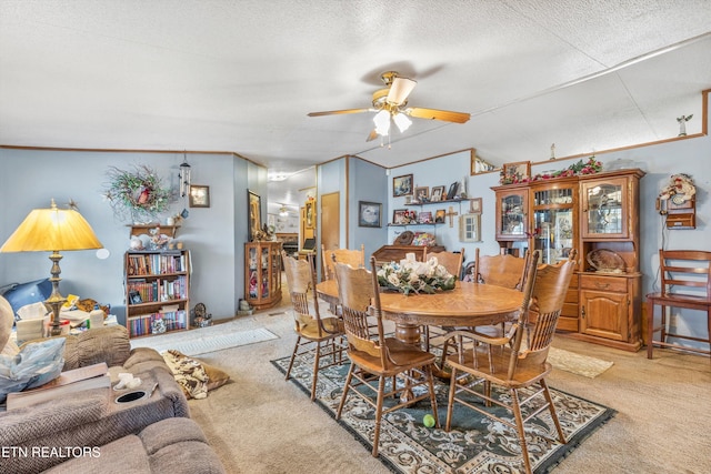 carpeted dining room with ornamental molding, a textured ceiling, and ceiling fan