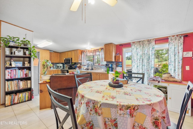 tiled dining space featuring sink, ceiling fan, and plenty of natural light