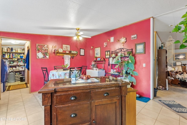 kitchen featuring ceiling fan, a textured ceiling, and light tile patterned floors