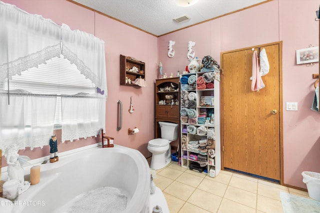 bathroom featuring a textured ceiling, a tub to relax in, tile patterned floors, ornamental molding, and toilet