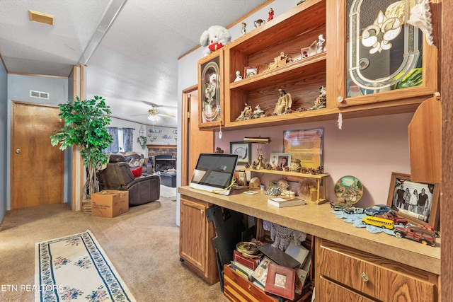 carpeted office space featuring a textured ceiling, vaulted ceiling, and ceiling fan