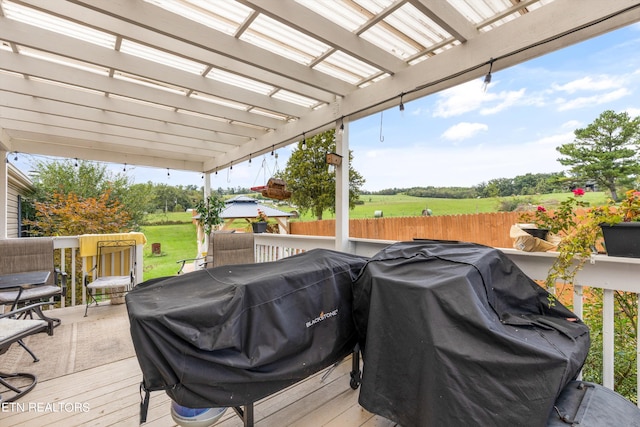 deck with area for grilling, a rural view, and a pergola